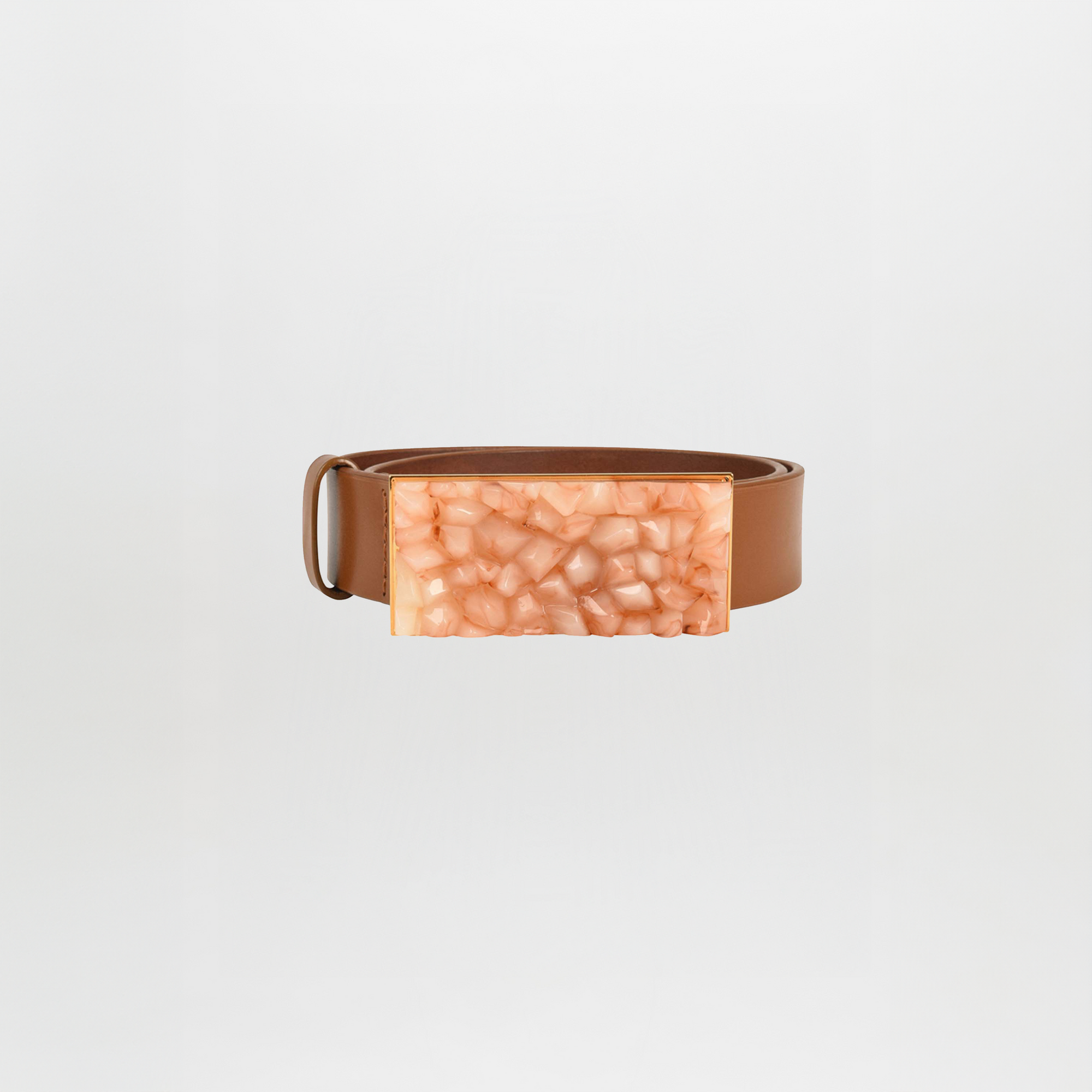 Make a statement with the Dora Belt Tan, a brown leather belt featuring a large rectangular buckle with a textured, peach-colored finish.