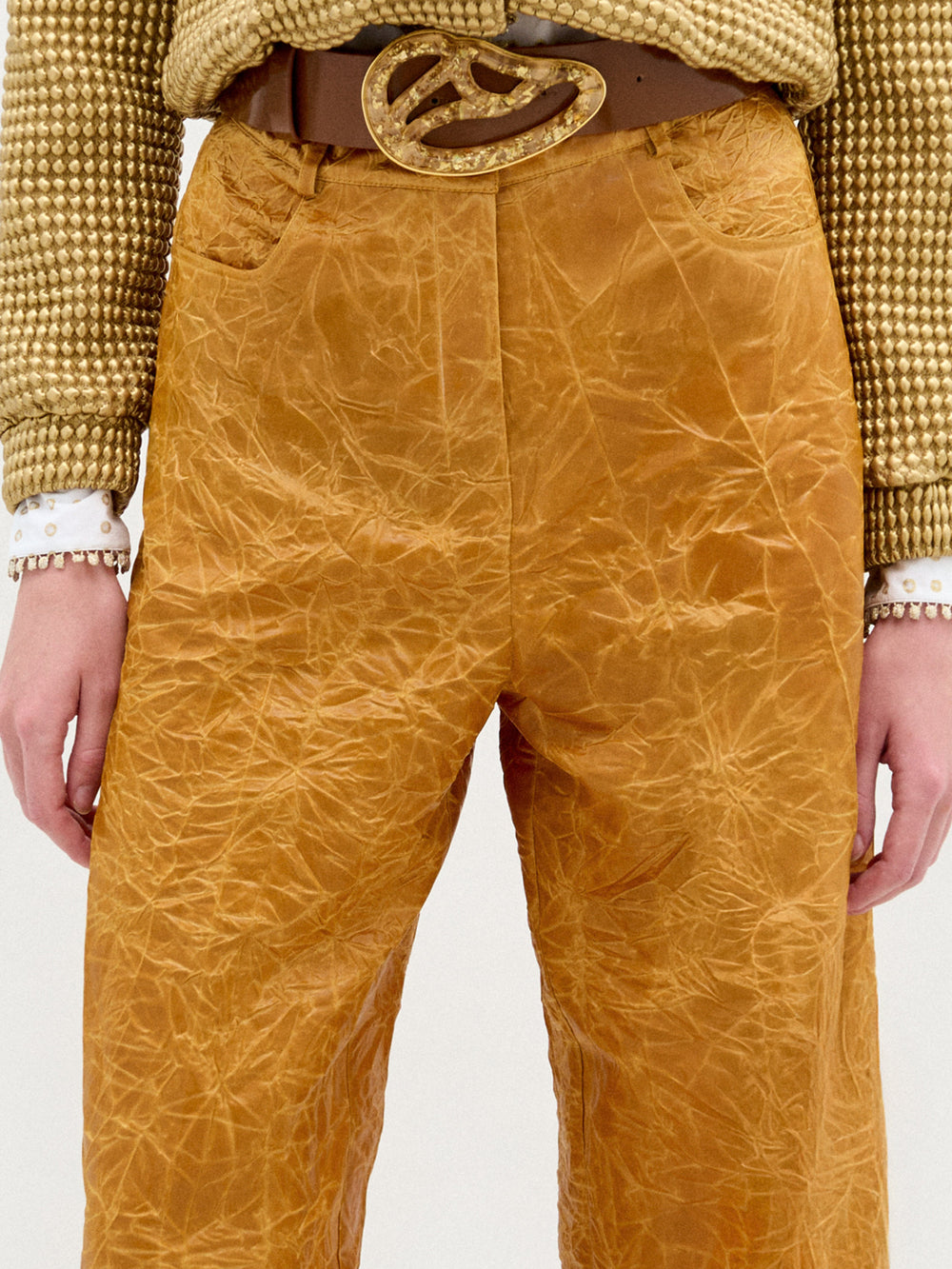 A woman wearing the Emine Pant in color Mustard on a white background.