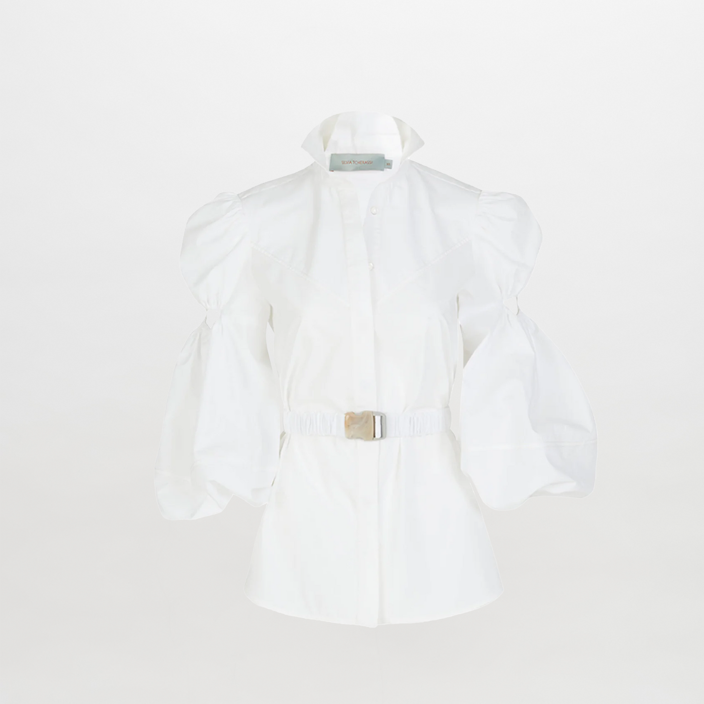 The Enio Blouse White is a long-sleeve shirt dress with puffed sleeves, a high collar, belted waist with a rectangular buckle, and delicate floral embroidery, shown on a plain white background.