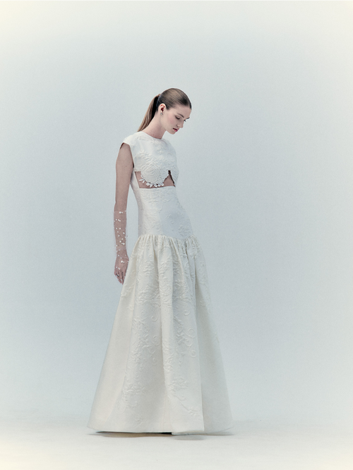 A woman in an Edith Dress Pearl, standing against a light background.