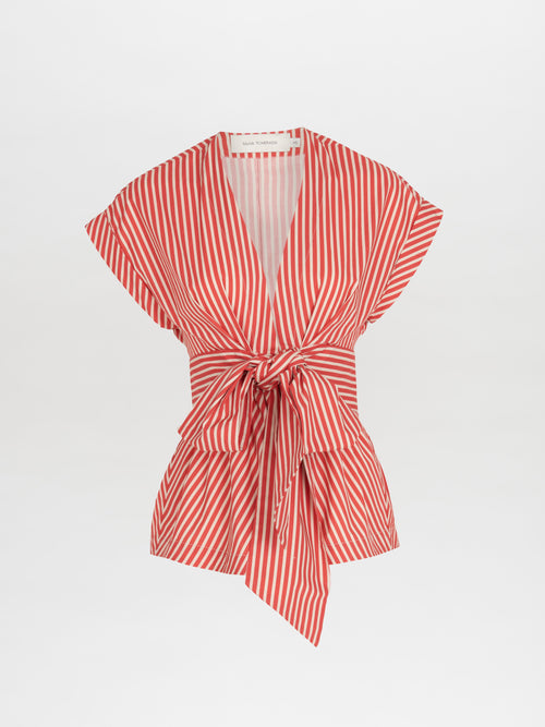 The Elia Blouse Red Willow features a red and white vertical stripe pattern, cap sleeves, and a waist-tie bow, crafted to enhance an hourglass silhouette.