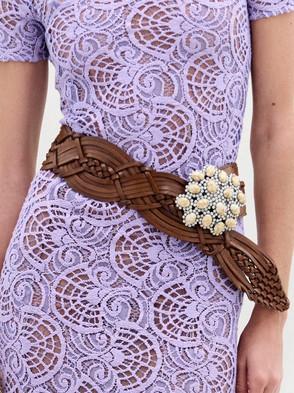The Eines Belt is a wide brown braided belt made from premium Italian leather, featuring a large decorative buckle with cream and white beads, shown against a plain white background.