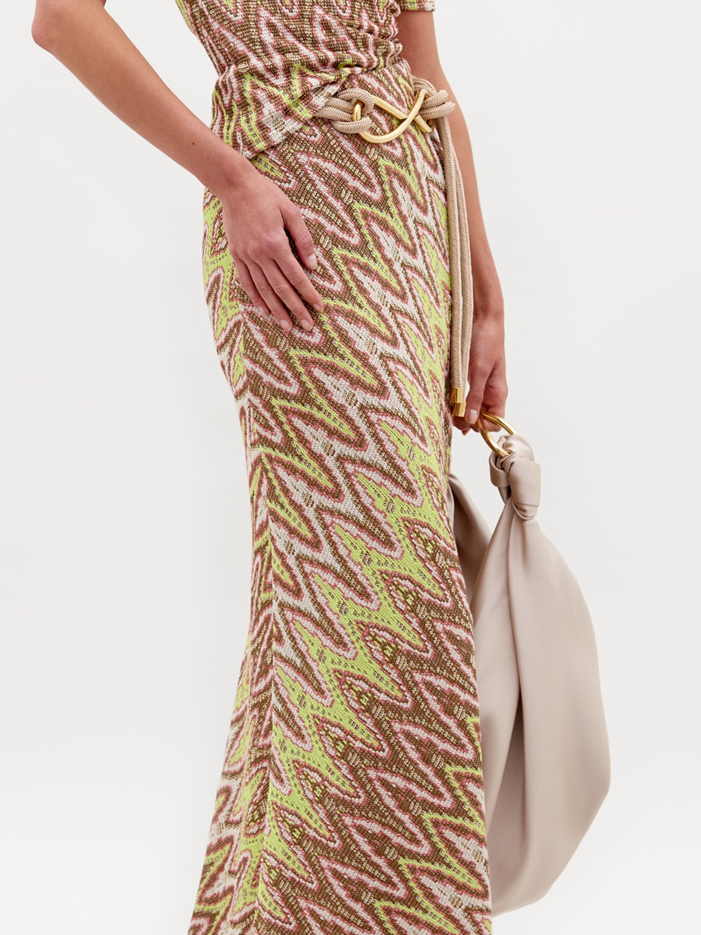 A person wearing the Famara Skirt with the Sofia Bag Maxi in color Beige on a white background.