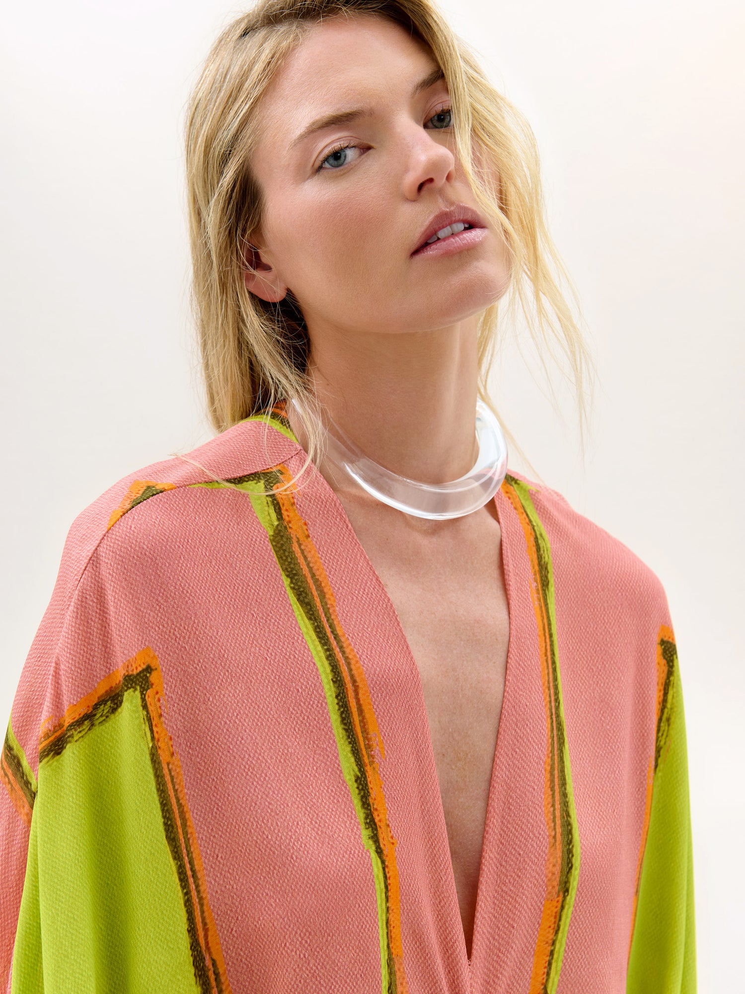 Woman wearing a colorful cardigan with a plain background