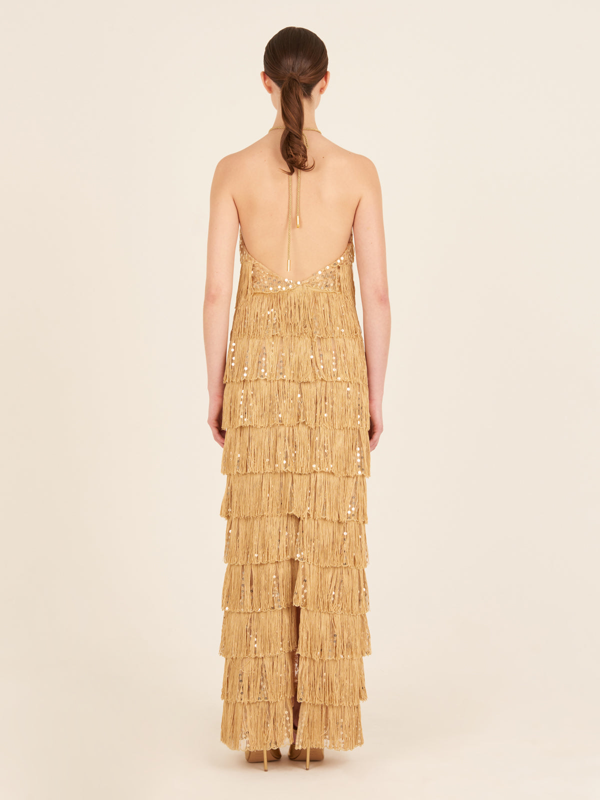 Oriana Dress Gold with tiered gold fringe detailing, displayed on a white background.