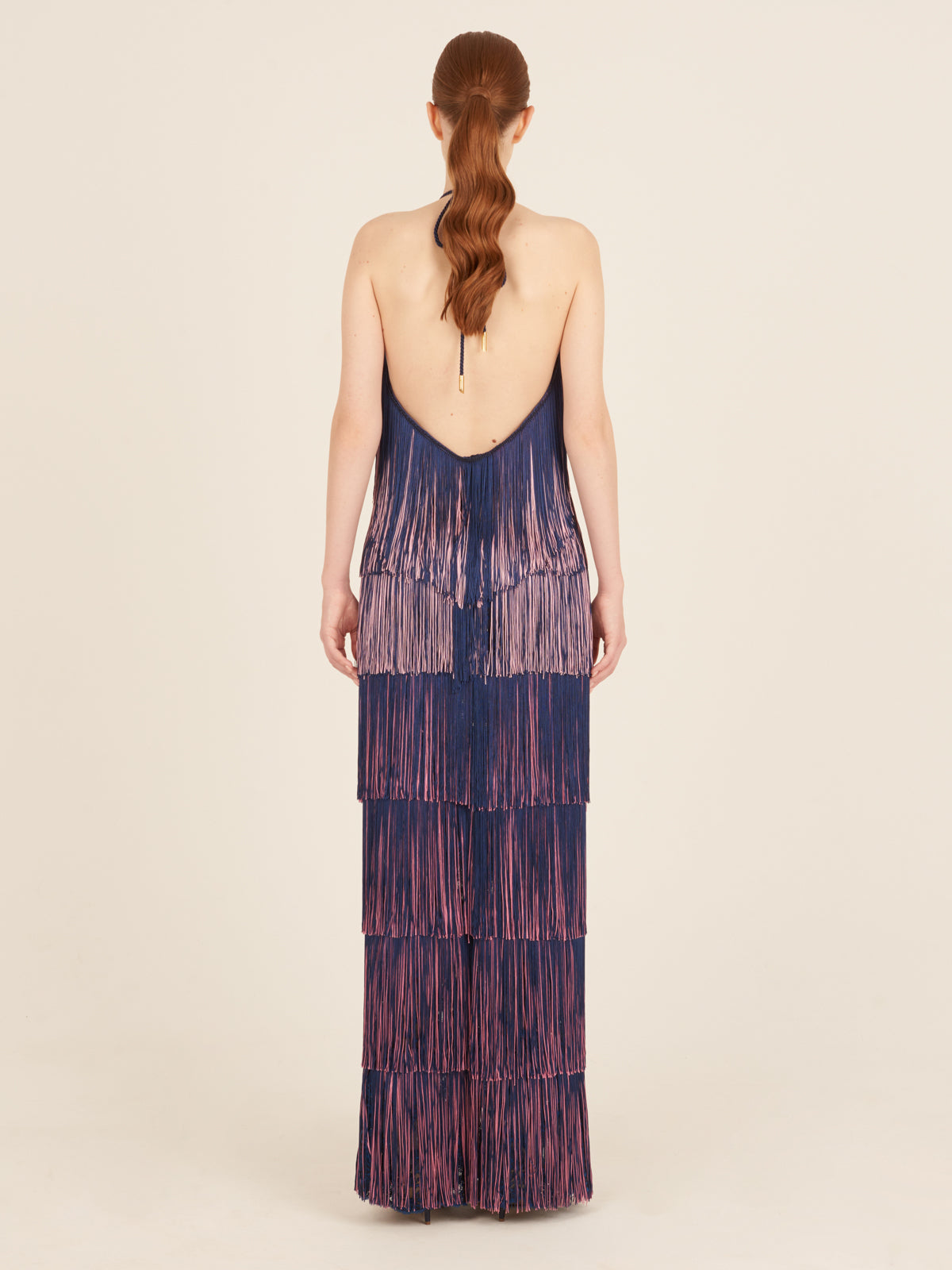 A floor-grazing fringed Paris Dress Navy with a touch of glamour in blue and pink hues.