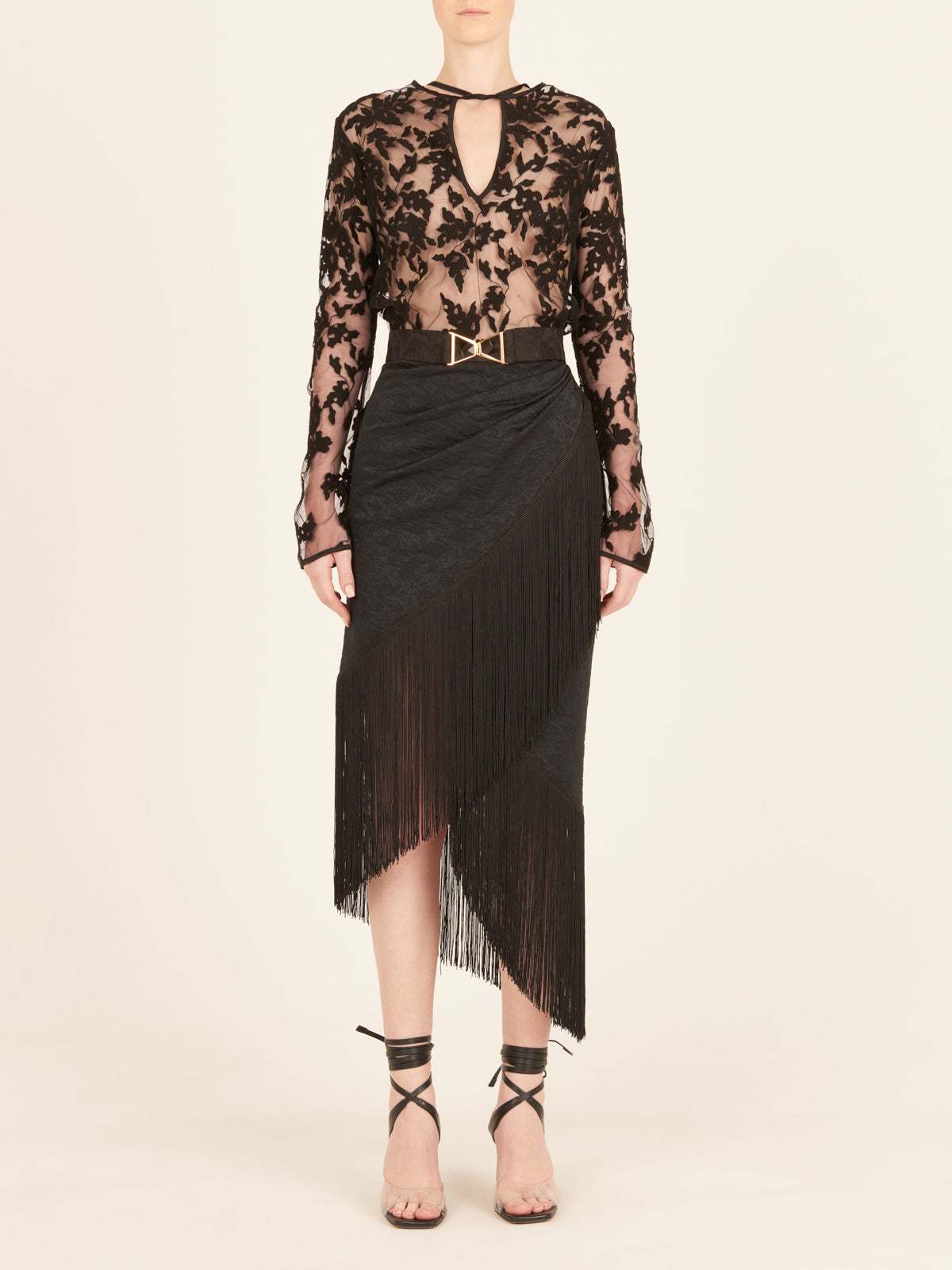 A black skirt with fringes on an asymmetrical hem, resembling the Natalia Skirt Black.