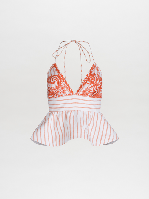 The Fabiola Blouse is a sleeveless halter top featuring embroidered paisley, vibrant orange accents, vertical stripes, and a peplum effect at the waist with elegant neck ties.