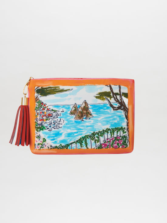 The Faraglioni Clutch beautifully depicts a Capri-inspired coastal scene, showcasing a vibrant blue sea, rocky islands, charming houses, and delicate pink flowers. It is accented with a tassel on the zipper and subtly sparkles with embedded Swarovski crystals.