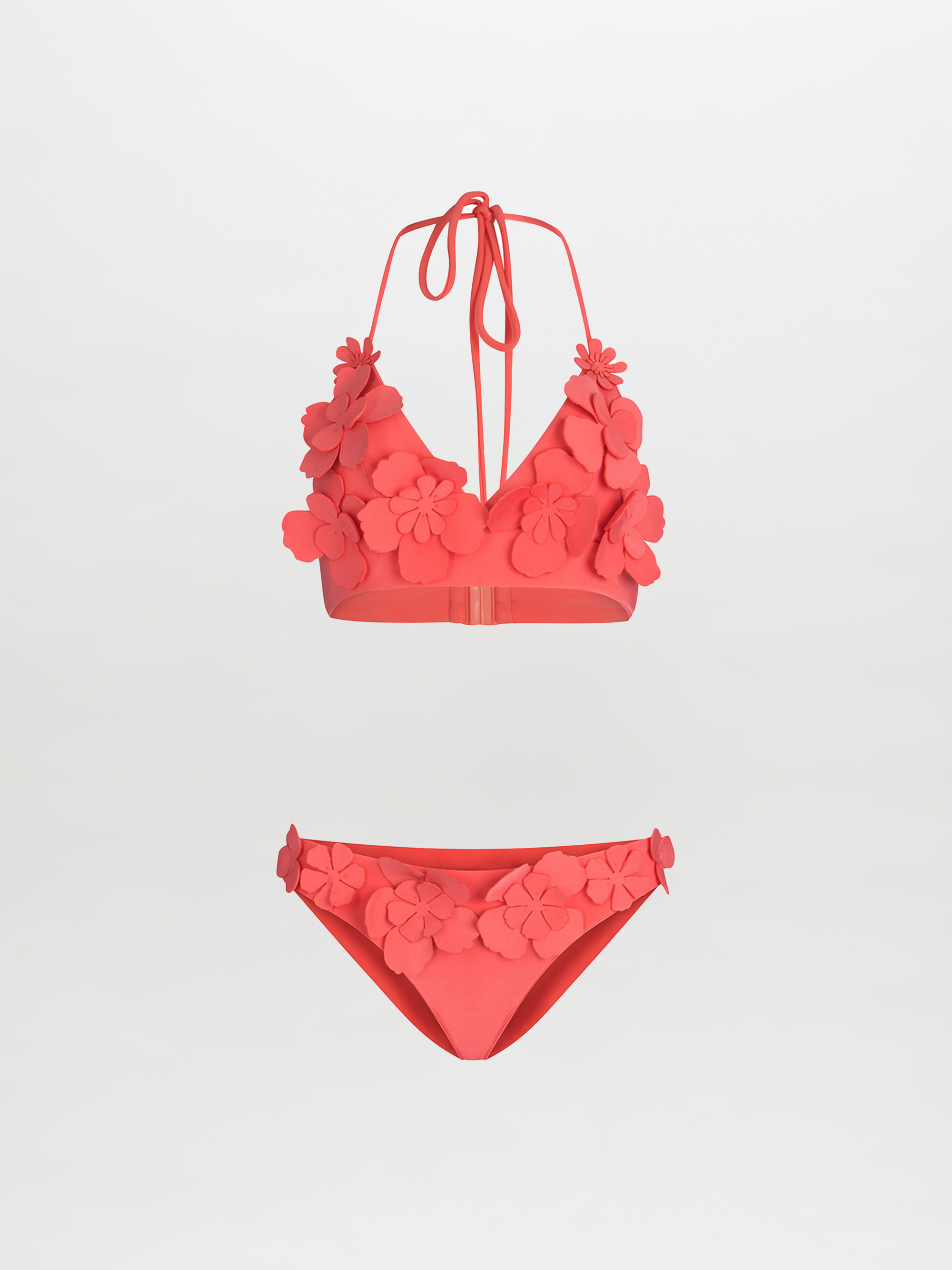 The Felisa Top + Fermina Bikini is a coral pink set with a halter V neckline and 3D floral accents on the top, paired with matching bottoms, shown against a plain white background.