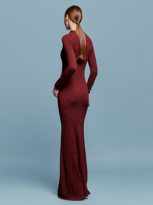 The model is wearing a pre-order Gabbice Dress Burgundy, set to ship by August 15th.