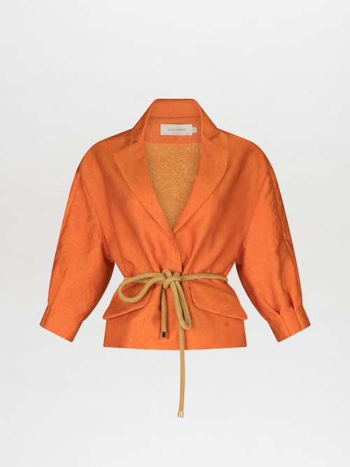 A women's Gianna Jacket Orange Petal with a belt, featuring a relaxed fit.