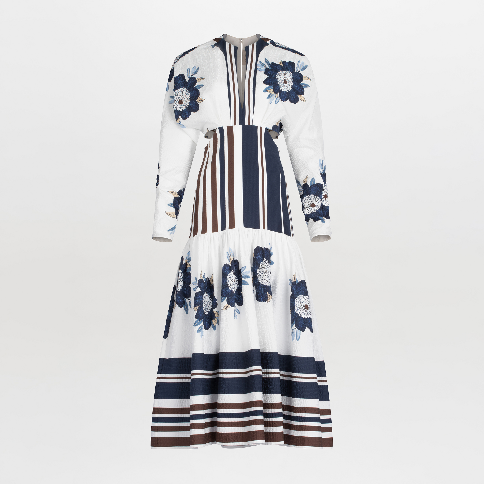 A long-sleeved Gabina Dress Multi Navy Brown Floral featuring a white base with blue floral patterns and horizontal navy stripes, designed with a flared skirt, isolated on a white background.