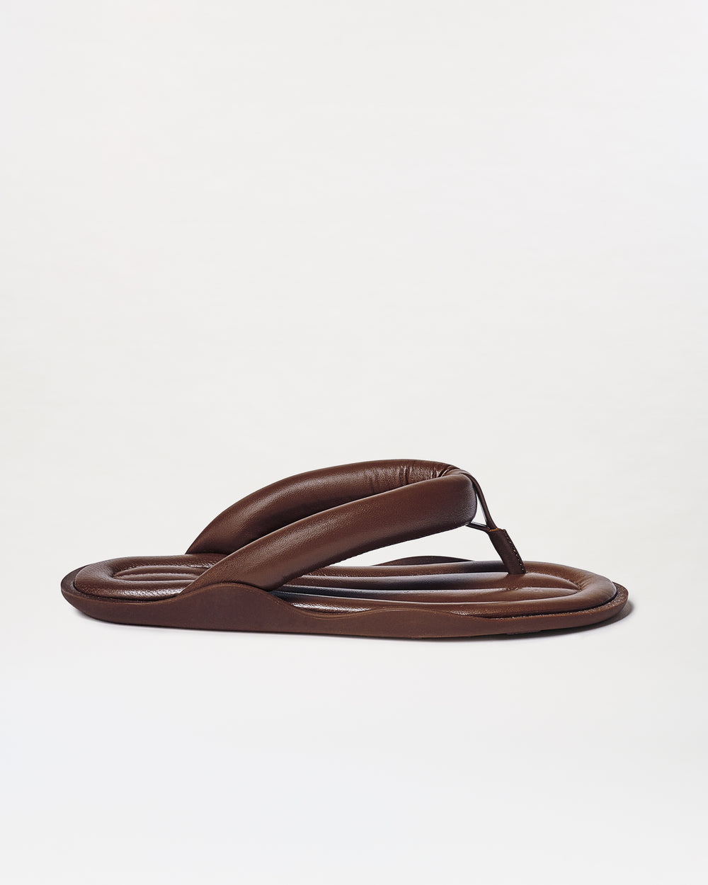 The Harper Sandals are brown padded flip-flops featuring thick, cushioned straps and a rounded sole, shown on a plain white background.