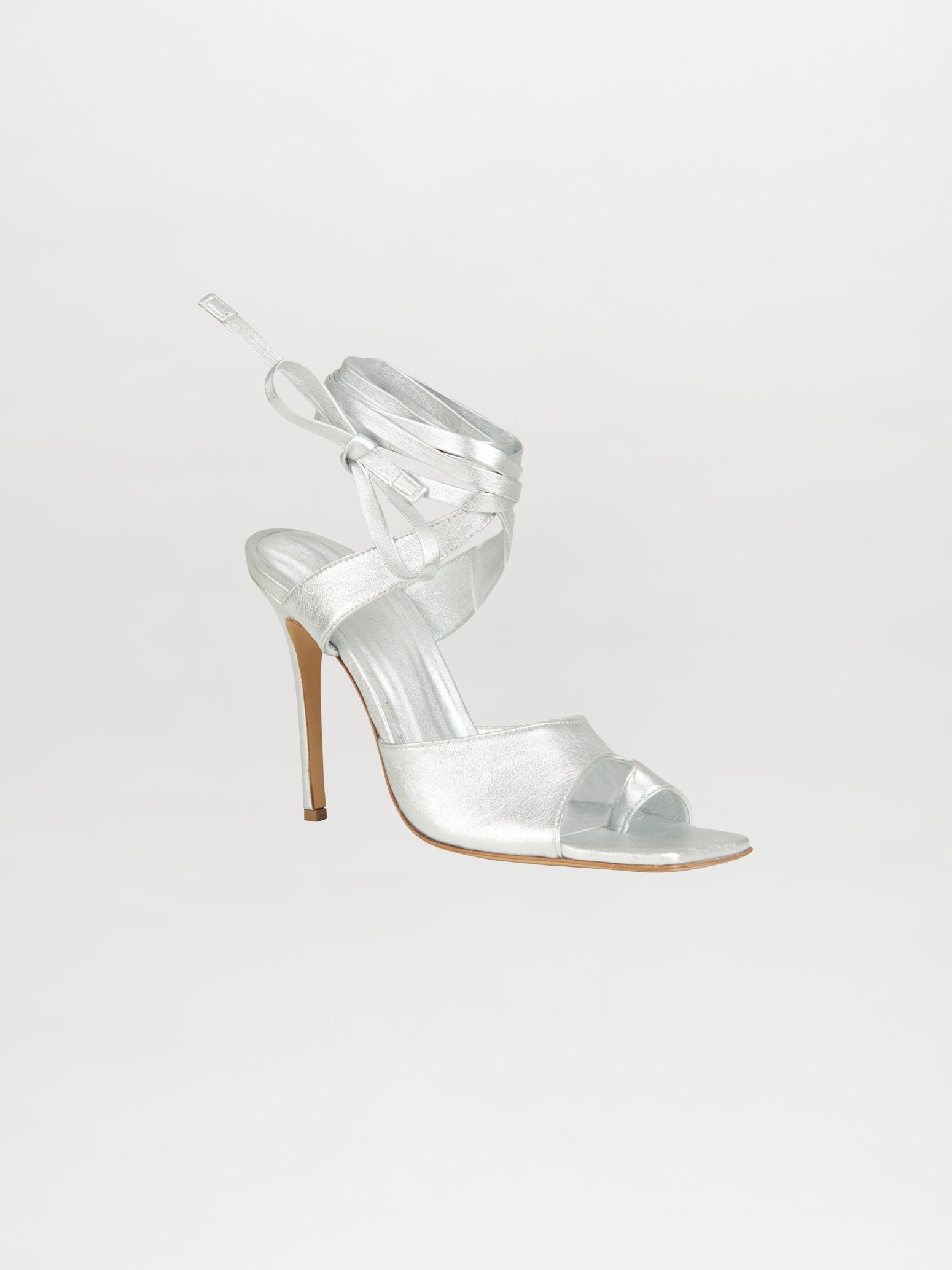 The Gia Borghini collaboration introduces the Golda Heels Silver, a stunning silver high-heeled sandal featuring ankle wrap straps on a light background, ideal for anyone who values style and elegance.