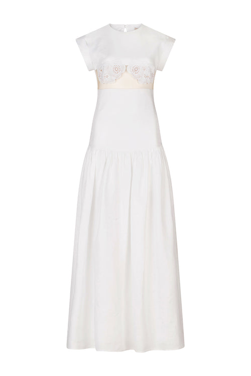 A Hanane Dress White with lace trim and a fitted silhouette.