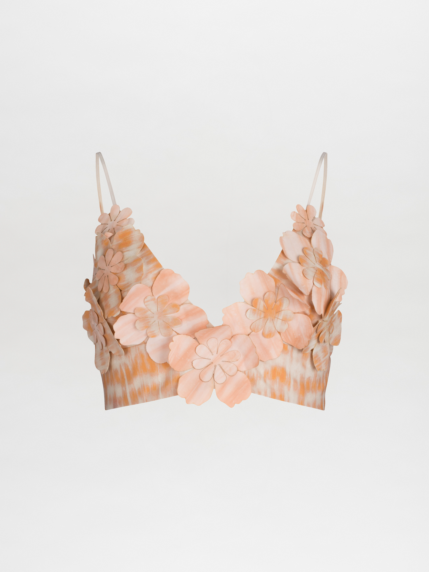 The Ibbie Top Mediterranean Coral Blue is a crop top bralette with spaghetti straps, showcasing exquisite floral detailing and 3D flower embellishments in soft shades of peach and beige on a plain white background.