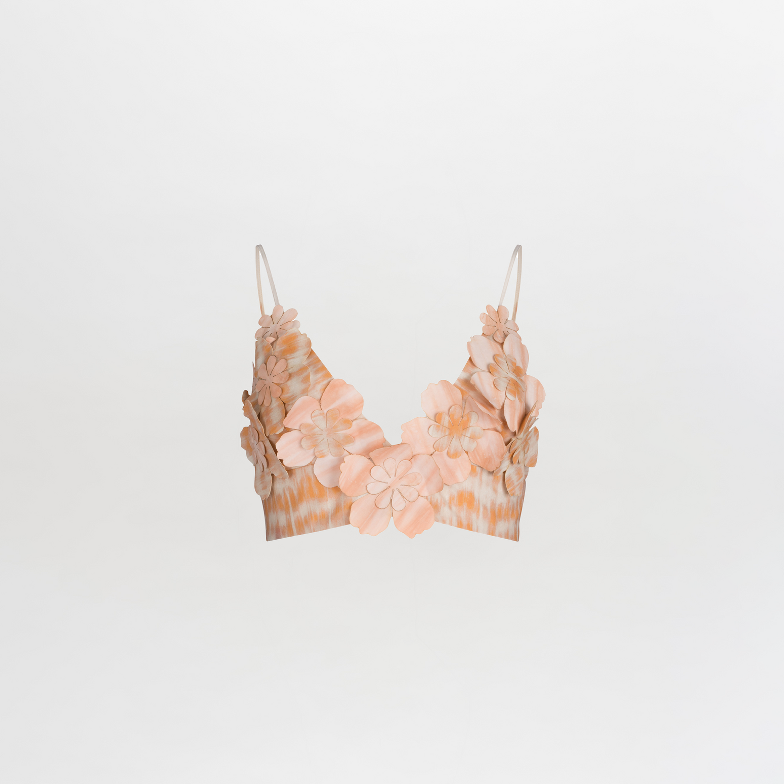 The Ibbie Top Mediterranean Coral Blue is a crop top bralette with spaghetti straps, showcasing exquisite floral detailing and 3D flower embellishments in soft shades of peach and beige on a plain white background.