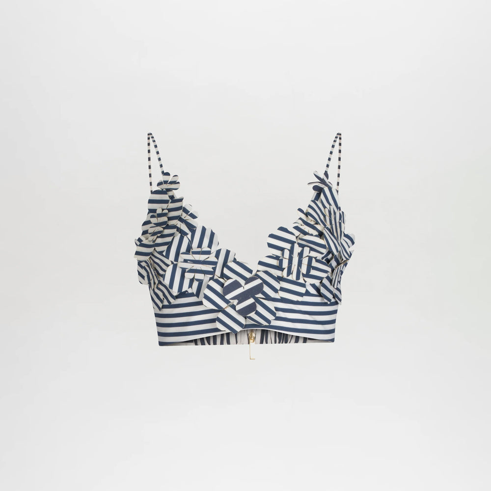 The Ibbie Top is a blue and white striped crop top with thin straps and ruffled 3D accents on the neckline and chest, offering a playful, fitted style. Shown against a plain white background.