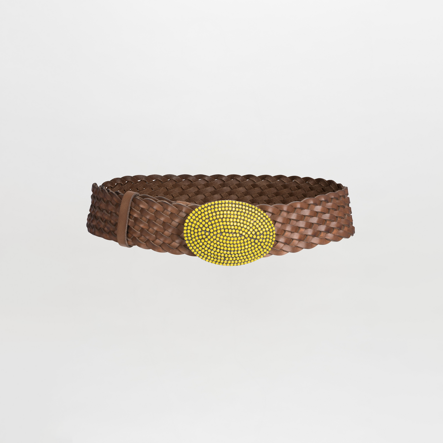 The Irene Belt is a braided leather accessory with a bold round yellow beaded buckle set against a pristine white background.