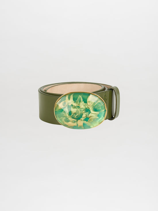 The Irene Belt Green, crafted from Italian leather, features a prominent oval resin buckle adorned with an abstract green and yellow design that embodies the spirit of Fall 2023.