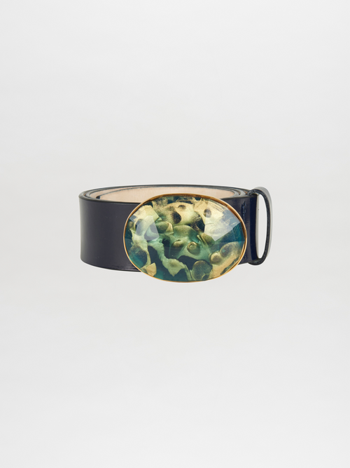 Introducing the Irene Belt Navy: an Italian leather belt in a sophisticated deep navy with a glossy texture and an oval resin buckle showcasing a green and gold abstract pattern, making it an ideal accessory for Fall 2023.