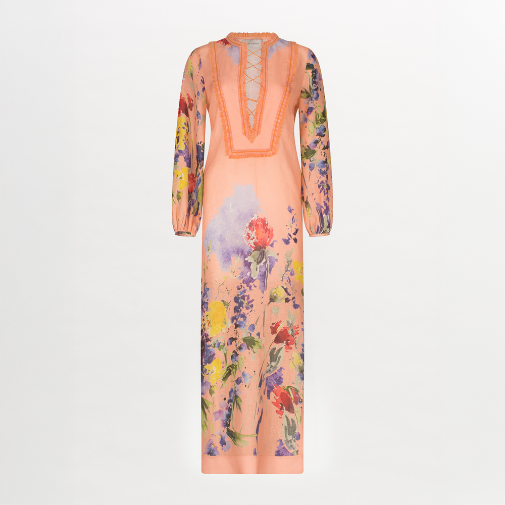 A long-sleeved, peach-colored Isernia Tunic Apricot Spring Garden with a floral pattern and fringe lace detailing on the chest. The tunic features vibrant flowers in various colors, including red, yellow, and purple.