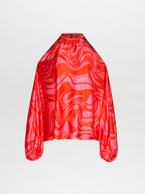 The Janina Blouse showcases a red and pink abstract pattern with a high neckline and romantic batwing sleeves that add a touch of elegance.