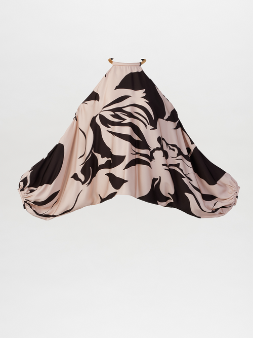 The Janina Blouse Cacao Rose Gardena features a large, flowing design with an abstract floral pattern in black and beige on a white background, complete with elegant batwing sleeves for added flair.