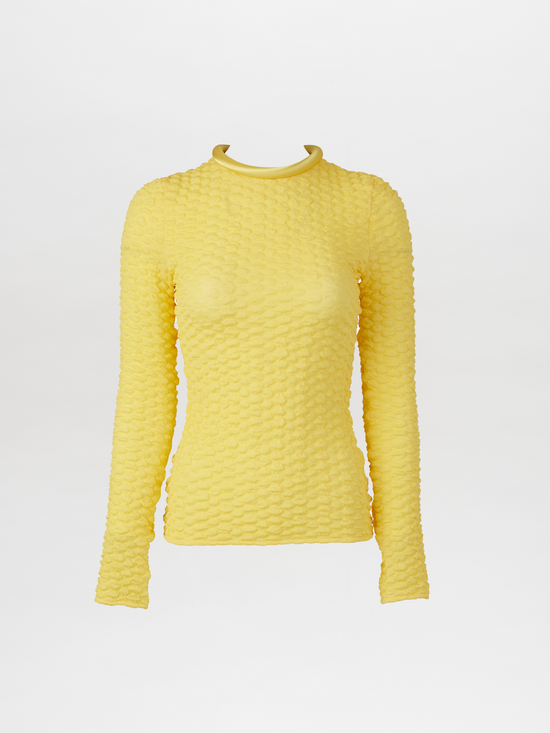 A versatile, long-sleeved Jari Top Yellow with a ruffled neckline made from embossed jacquard fabric.