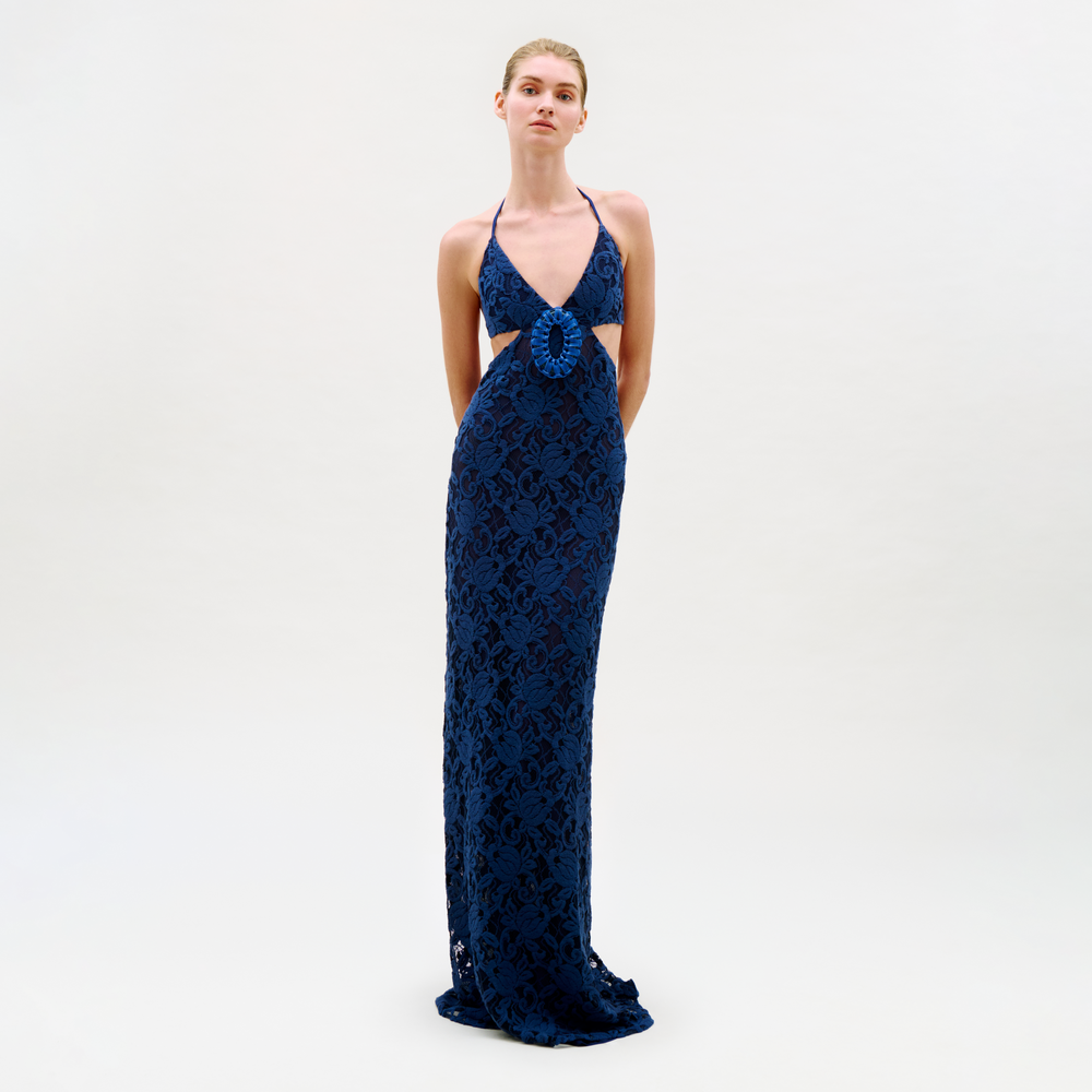 Woman wearing a blue lace evening gown on a white background