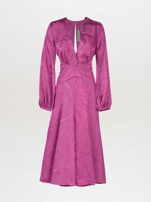 A long-sleeved, floor-length Kathryn Dress Magenta Orchid Jacquard with a V-neck and criss-cross bodice, featuring a subtle jacquard pattern and a tag near the neckline.