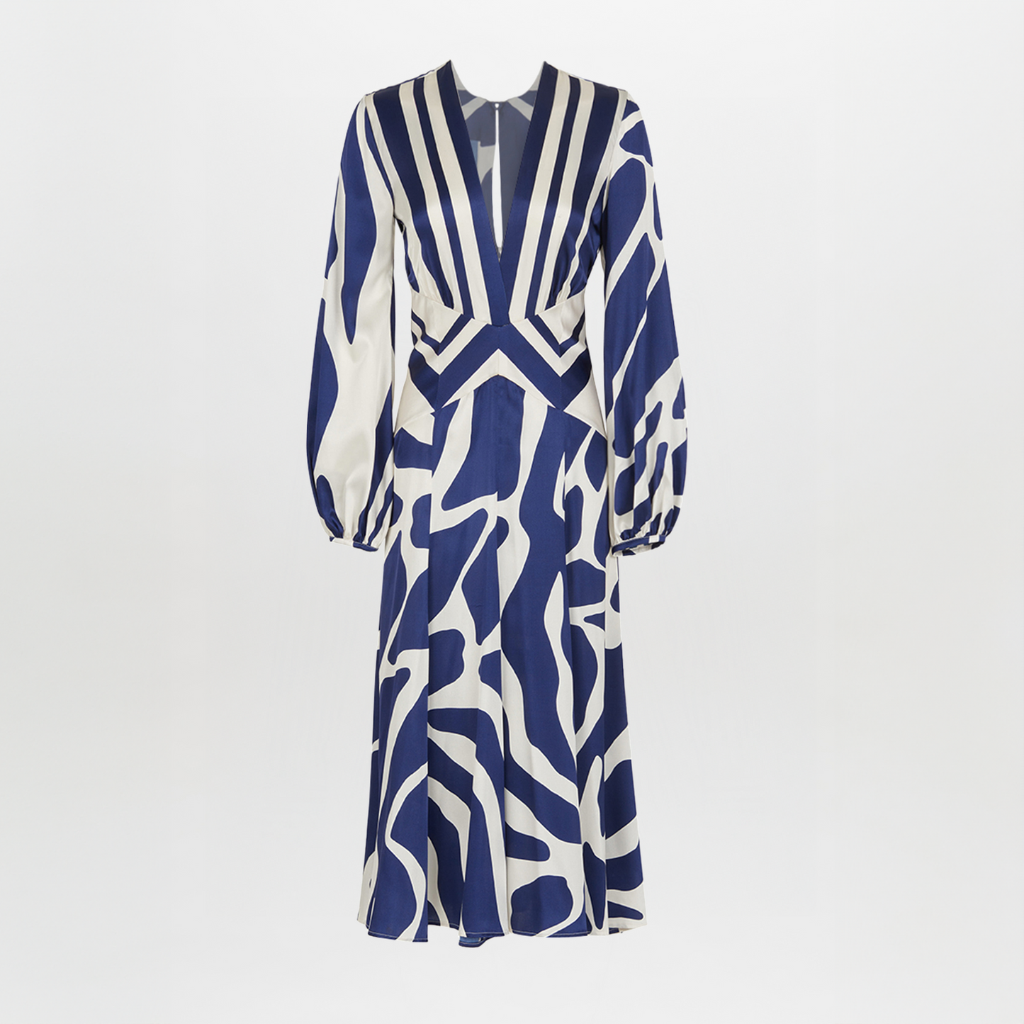 The Kathryn Dress Navy White Mosaic is a knee-length piece with a deep V-neckline and long sleeves, featuring a bold blue and white mosaic print that captures the essence of Spring 2023.