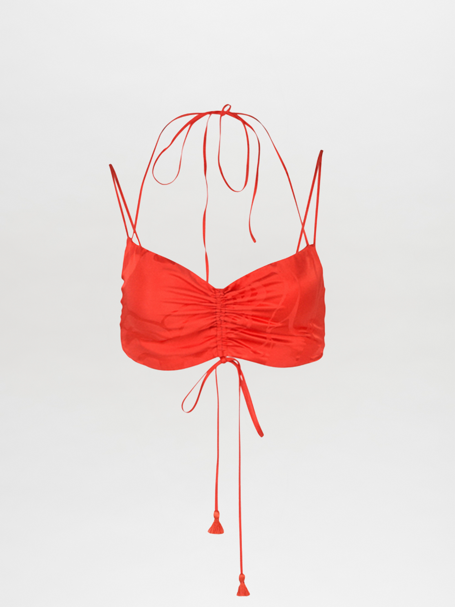 The Kayla Top Crimson Jacquard is a cropped camisole with thin straps and a halter neck tie, featuring ruching detail at the front and long tassel ties hanging down.