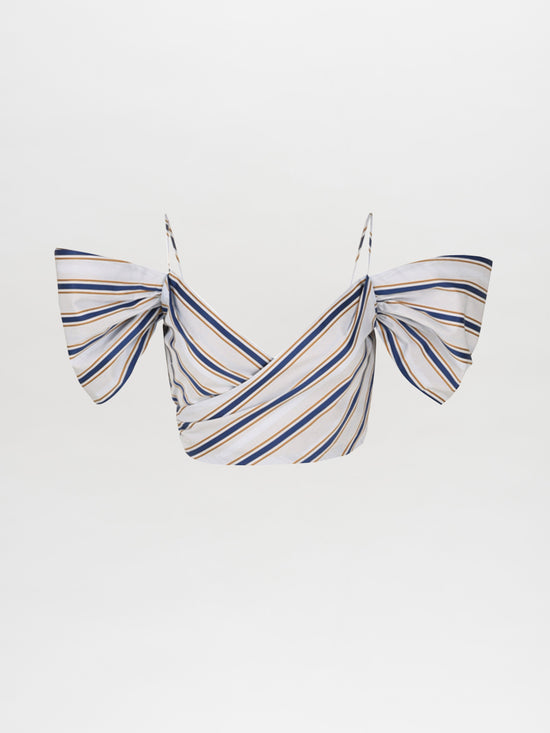 The Khandi Top in Camel Navy Stripes by Silvia Tcherassi showcases a cropped design with striped geometric patterns, a crisscross front, and ruffled off-the-shoulder sleeves set against a plain backdrop.