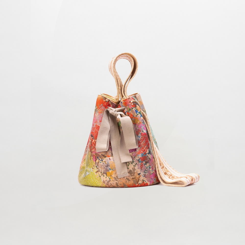 Colorful drawstring bag with floral pattern on a light gray background