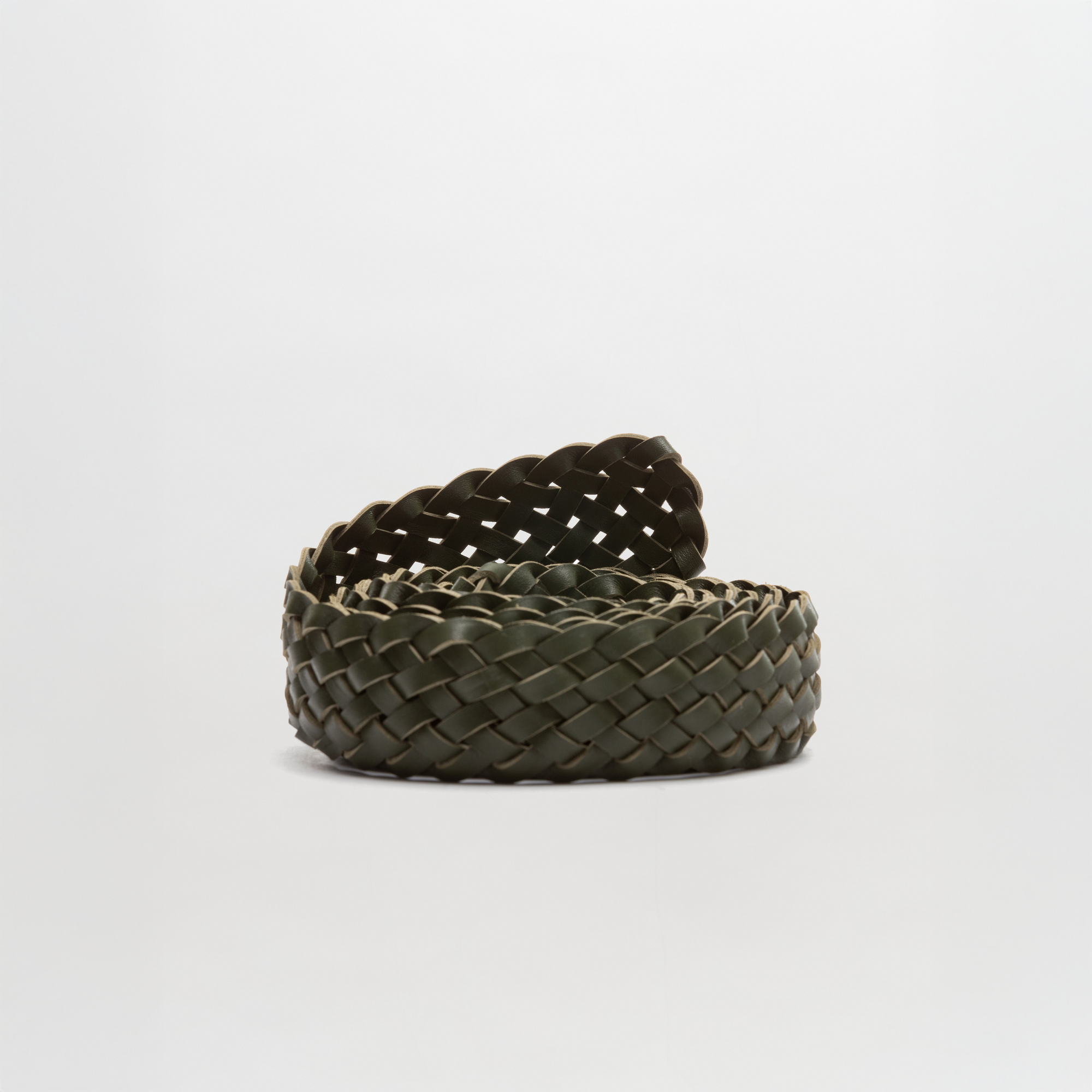 The Lauren Belt, crafted in Colombia, features a coiled design with dark green woven leather and is shown on a plain white background.