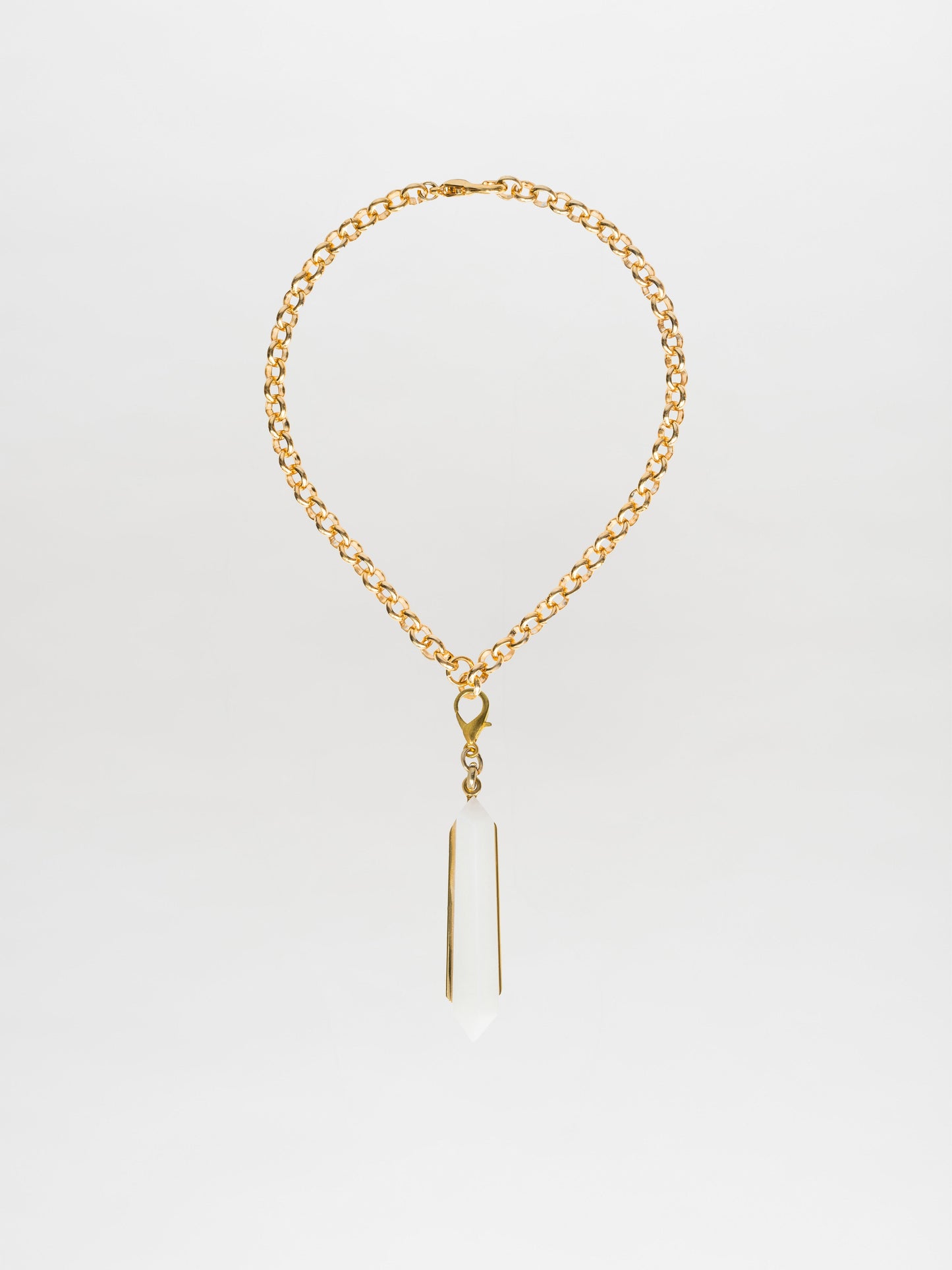 The Mariela Necklace Pearl is a gold-plated brass choker featuring a geometric crystal pendant, beautifully displayed against a white background.