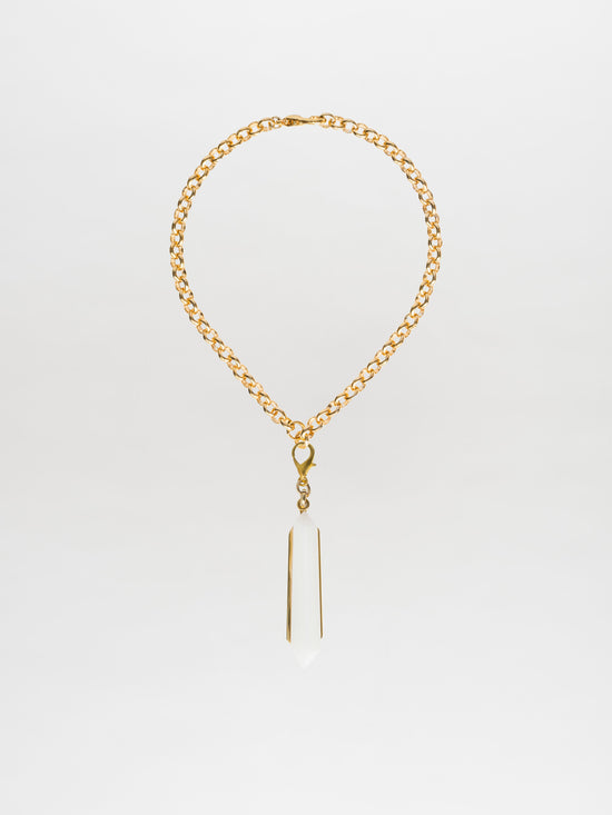 The Mariela Necklace Pearl is a gold-plated brass choker featuring a geometric crystal pendant, beautifully displayed against a white background.