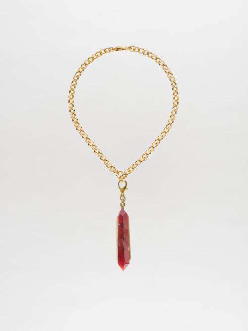 Introducing the Mariela Necklace Rouge: a gold chain choker featuring a striking geometric crystal pendant in red, showcased against a clean white background.