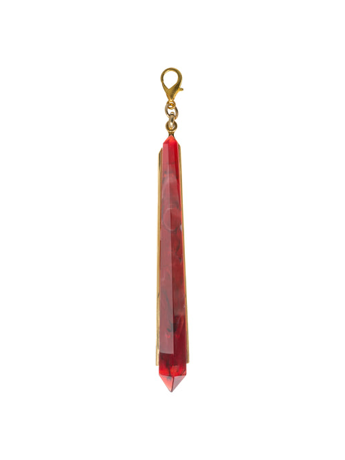 The Montse Charm Rouge is a single long, red, faceted pendant adorned with gold accents and featuring a lobster clasp at the top. It's perfect for adding a touch of elegance to any outfit and is ready to ship by September 2nd.