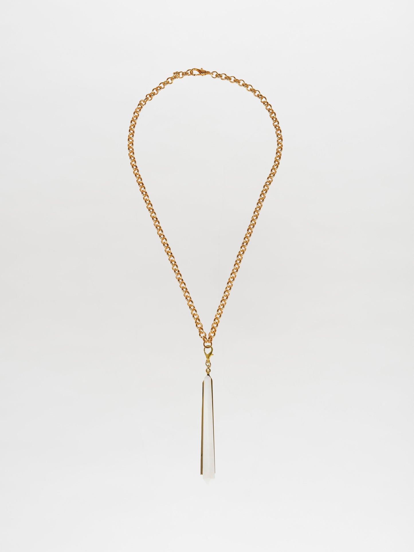 The Montse Necklace Pearl, a gold chain necklace with a long, pointed geometric crystal pendant on a white background, embodies the elegance of a Tcherassi design.