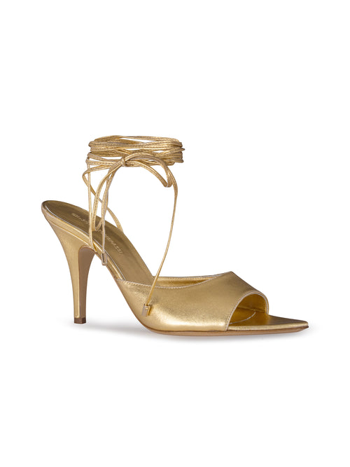 The Muna Heels Gold, a high-heeled sandal featuring an open toe and ankle wrap strap, are perfect for those elegant events on August 19th or September 2nd, 2024.