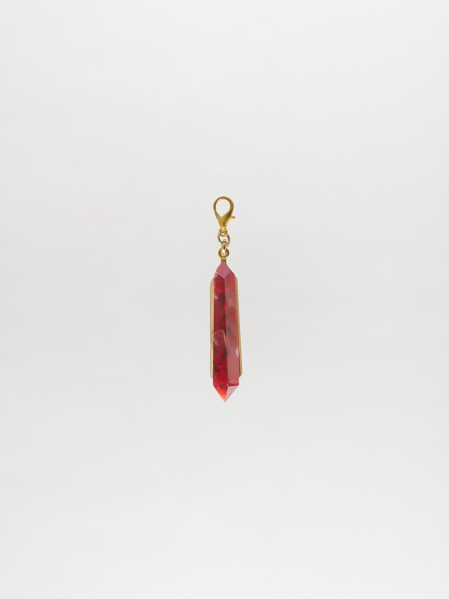 Introducing the Mariela Charm Rouge: A stunning red crystal pendant with a gold setting and clasp, perfect for any occasion. Order now for shipping on September 2nd.