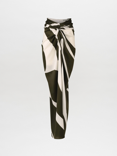 The Marina Skirt features a long, asymmetrical design with a dark green and white abstract palm silk pattern.