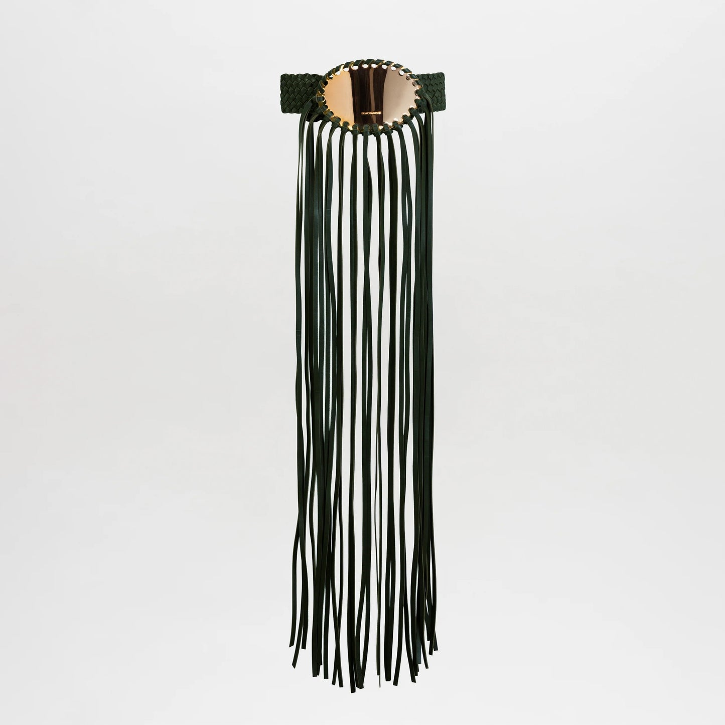 The Maya Belt is a wide, dark green leather accessory with a large round gold-plated buckle and long green fringe detail, shown against a plain white background.