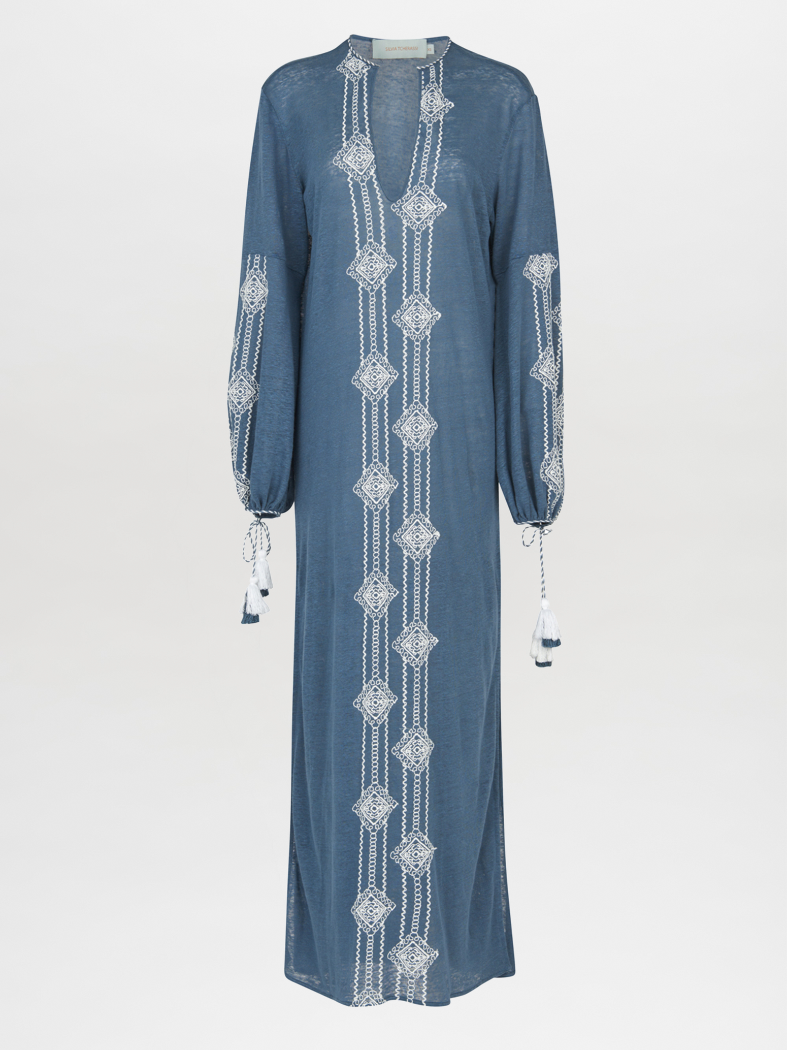 A navy blue, long-sleeved Mayfair Tunic Navy Embroidered with a V-neckline featuring white geometric embroidery down the front and on the sleeves, finished with tasseled ties at the cuffs.