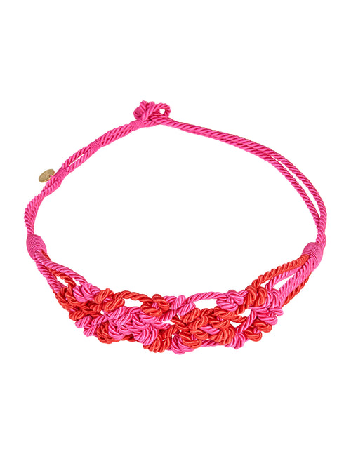 A pink and red braided rope Bresia Belt Fuchsia with a knot clasp and a small metallic tag on one end. Order now, and it will ship within 1-3 days.