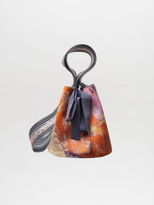 Mochila Laaput Gray with a textured, multicolored design, featuring a looped handle and fabric ribbons—a unique piece showcasing traditional craftsmanship.