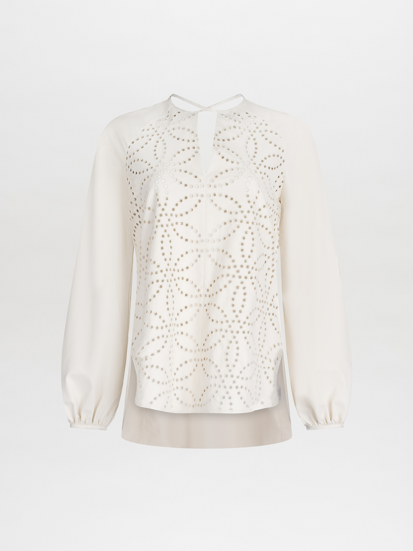 The Molveno Blouse Pearl is a white long-sleeve ecoleather blouse, featuring a geometric pattern on the front, a keyhole neckline, and a rounded hem.